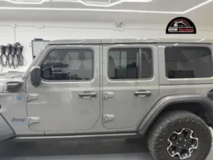 Side profile of a grey Jeep Wrangler in a detailing bay