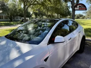 Close-up side view of a white Tesla Model 3 outdoors.