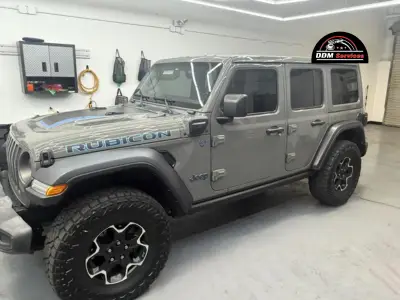 A grey Jeep Wrangler Rubicon parked in a professional auto detailing shop
