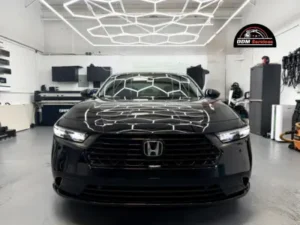 Front-facing view of a black Honda Accord showcasing a high-gloss finish from paint protection film