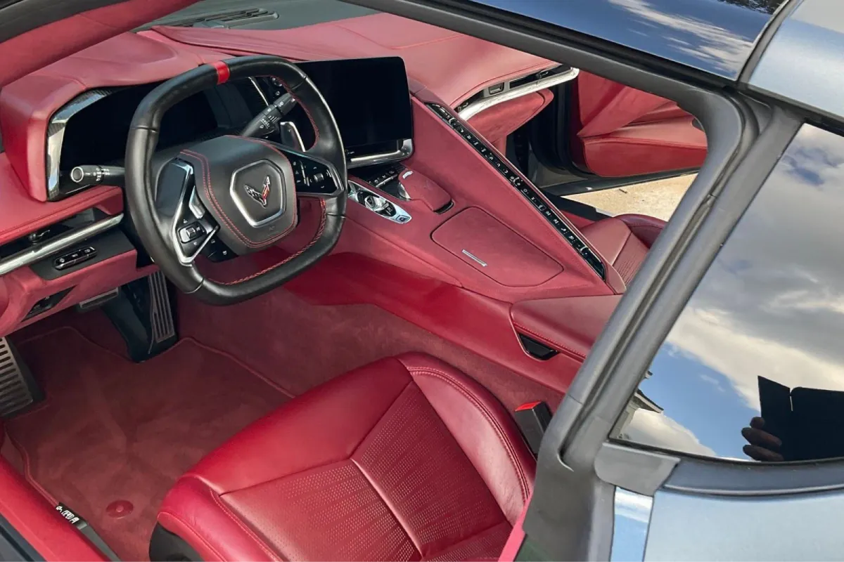 Interior of a Corvette with red leather seats and a sleek, luxurious design.